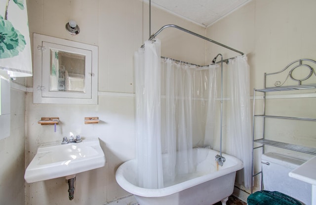 full bathroom featuring sink, shower / bathtub combination with curtain, ornamental molding, and toilet