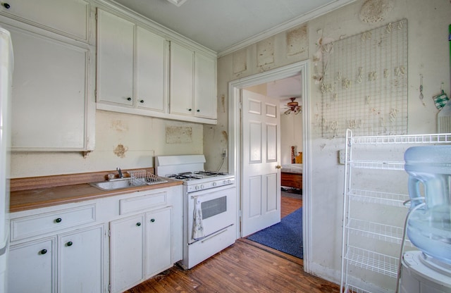 kitchen with sink, crown molding, hardwood / wood-style floors, white cabinets, and white gas range oven