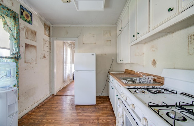 kitchen with white appliances, white cabinets, sink, dark hardwood / wood-style floors, and ornamental molding