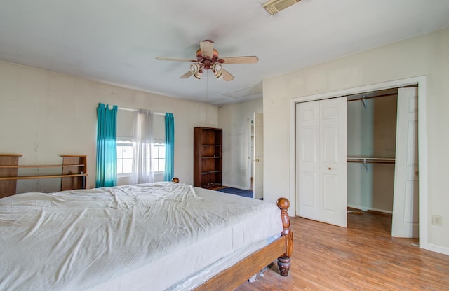 bedroom featuring ceiling fan, wood-type flooring, and a closet