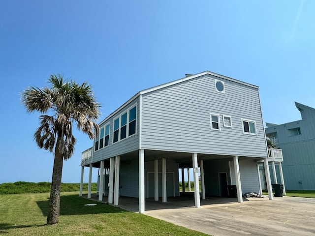 rear view of house featuring a carport and a yard