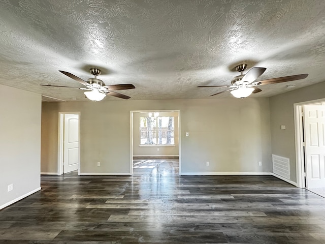 empty room featuring a textured ceiling and dark hardwood / wood-style floors