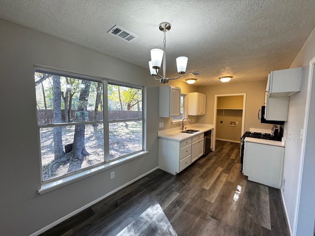 kitchen featuring white cabinets, sink, white gas range, decorative light fixtures, and dark hardwood / wood-style flooring