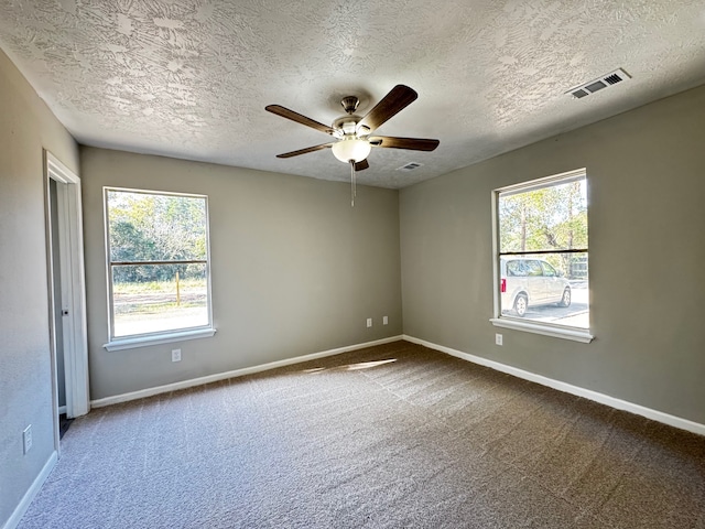 carpeted empty room featuring ceiling fan and a textured ceiling