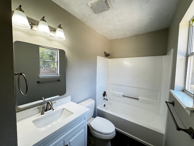 full bathroom featuring vanity, tub / shower combination, toilet, and a textured ceiling