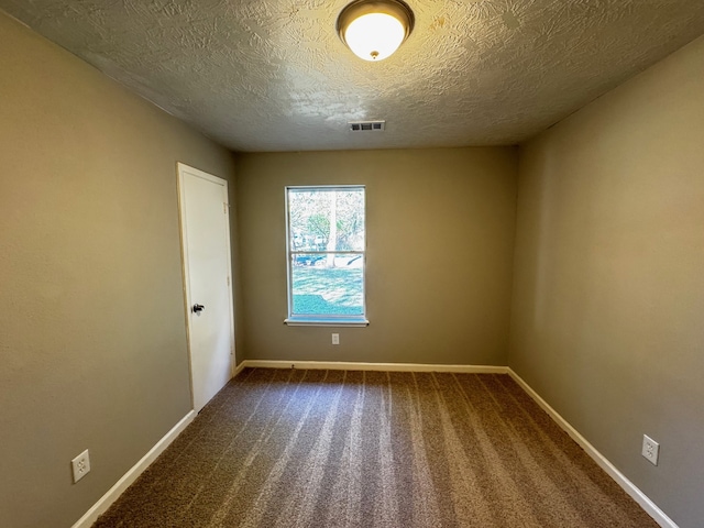 empty room with carpet flooring and a textured ceiling