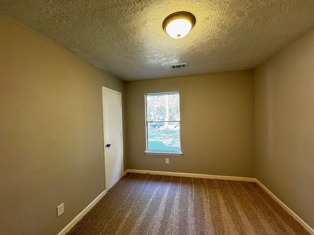 spare room featuring carpet and a textured ceiling