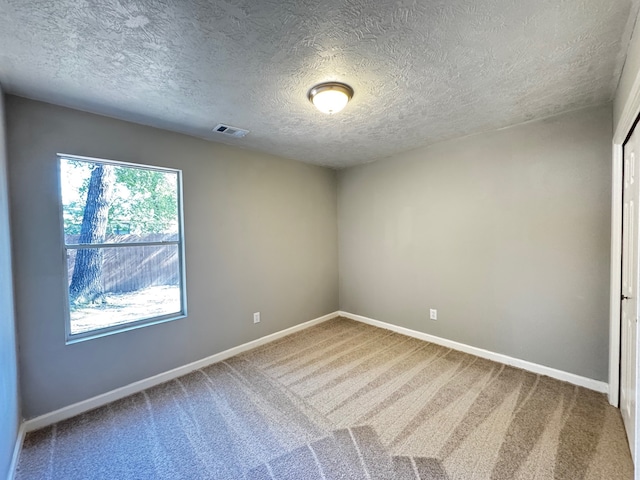 spare room with carpet and a textured ceiling