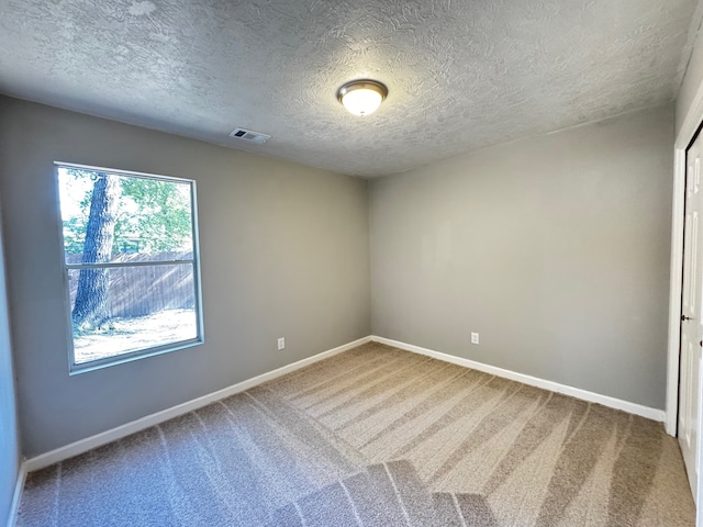 carpeted spare room featuring a textured ceiling