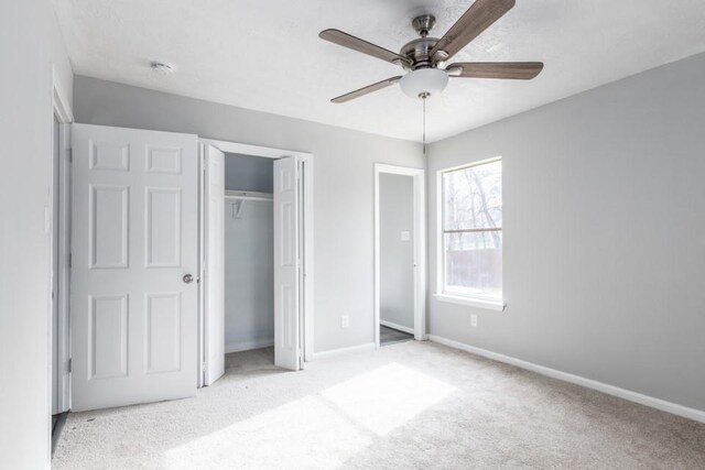 unfurnished bedroom with a closet, baseboards, carpet, and a ceiling fan