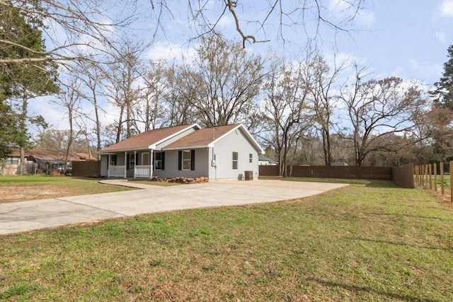 exterior space with covered porch, driveway, a front yard, and fence