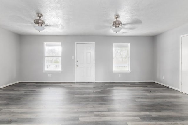 interior space featuring a wealth of natural light, baseboards, a ceiling fan, and wood finished floors