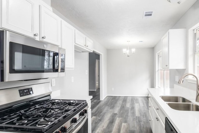 kitchen featuring a sink, stainless steel appliances, light countertops, and white cabinetry