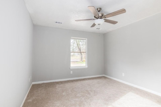 spare room with visible vents, carpet flooring, a ceiling fan, and baseboards