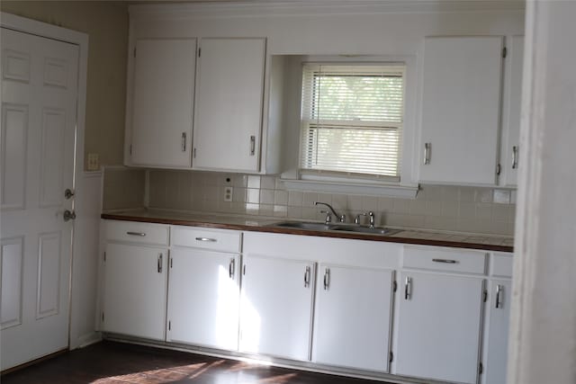 kitchen with white cabinets, backsplash, and sink