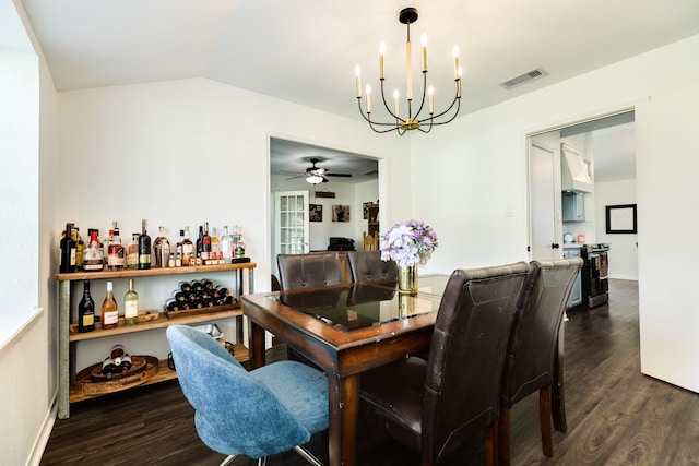 dining space featuring vaulted ceiling, bar area, dark wood-type flooring, and ceiling fan with notable chandelier