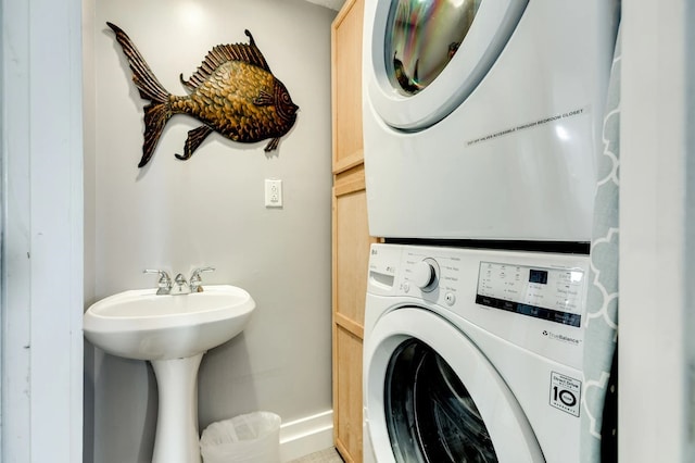 laundry room featuring stacked washing maching and dryer and sink