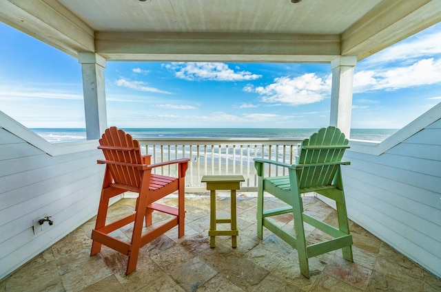 balcony featuring a water view and a view of the beach