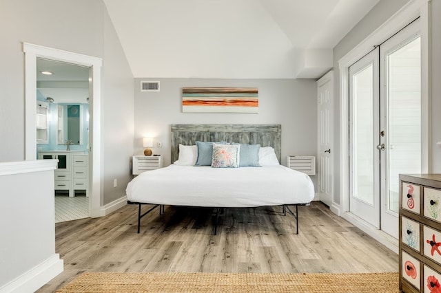 bedroom with french doors and light hardwood / wood-style floors