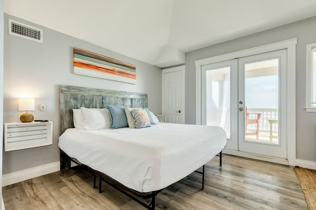 bedroom with access to exterior, french doors, and hardwood / wood-style flooring