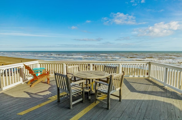 wooden deck with a water view and a beach view