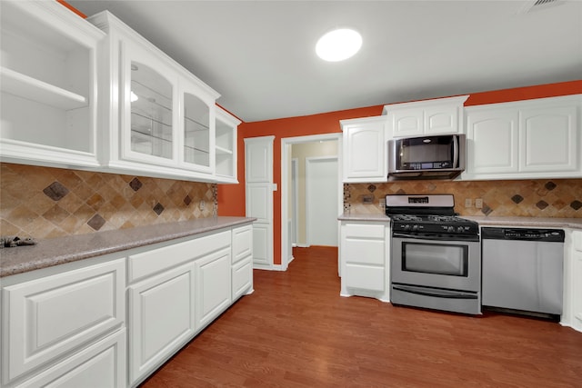 kitchen with white cabinets, appliances with stainless steel finishes, and decorative backsplash