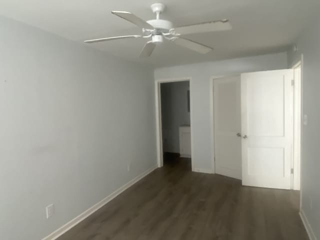 unfurnished bedroom with dark hardwood / wood-style flooring, a closet, and ceiling fan