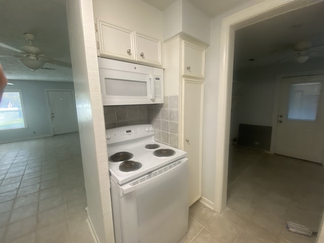 kitchen featuring white appliances, ceiling fan, tasteful backsplash, light tile patterned flooring, and white cabinetry