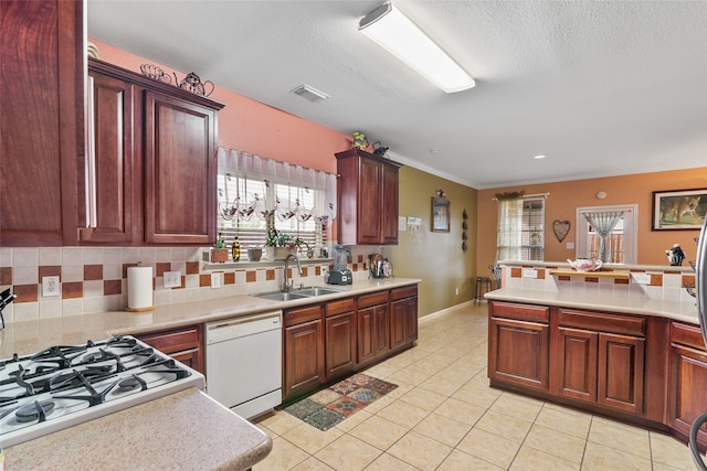 kitchen with sink, tasteful backsplash, white appliances, light tile patterned floors, and ornamental molding