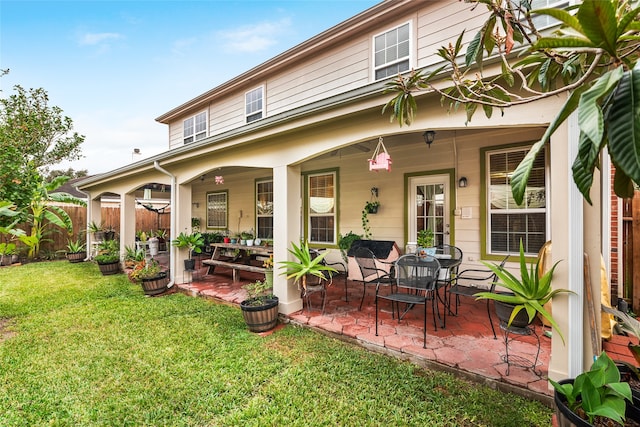 back of house with a lawn and a patio