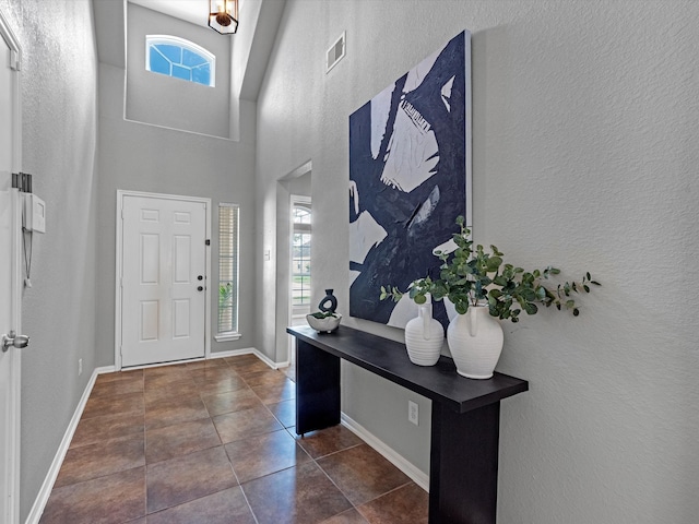 tiled entryway featuring a high ceiling