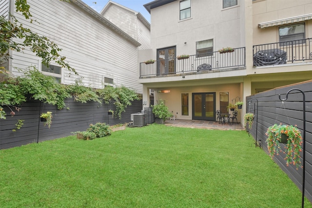 back of property featuring a lawn, central AC unit, a patio, and french doors