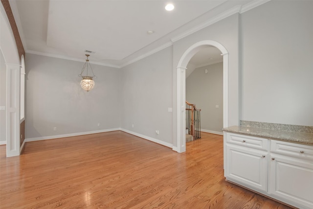 unfurnished dining area featuring crown molding and light hardwood / wood-style flooring