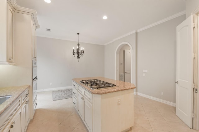 kitchen with light stone countertops, crown molding, a kitchen island, and pendant lighting