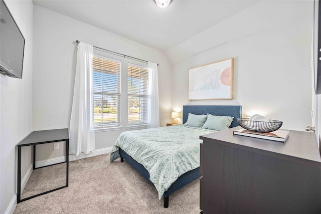 bedroom with light colored carpet and lofted ceiling