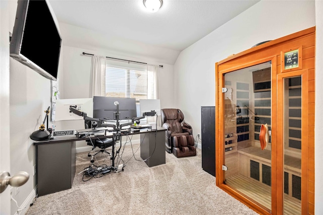 carpeted office space featuring vaulted ceiling