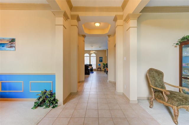 hallway featuring decorative columns, light tile patterned floors, and ornamental molding