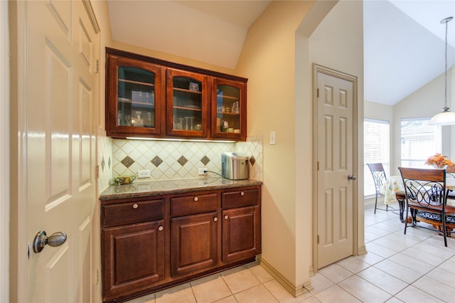 bar with lofted ceiling, light tile patterned floors, tasteful backsplash, baseboards, and decorative light fixtures