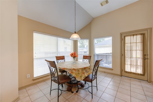 tiled dining room with plenty of natural light and lofted ceiling