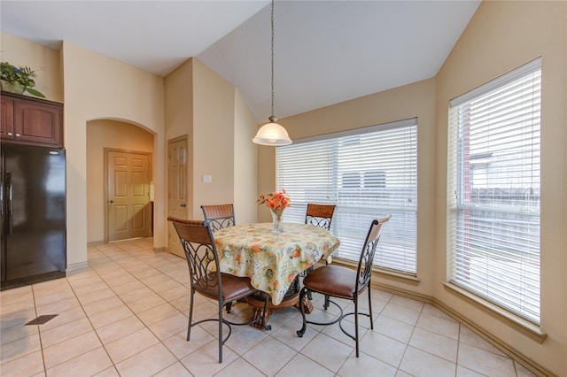 tiled dining space featuring lofted ceiling