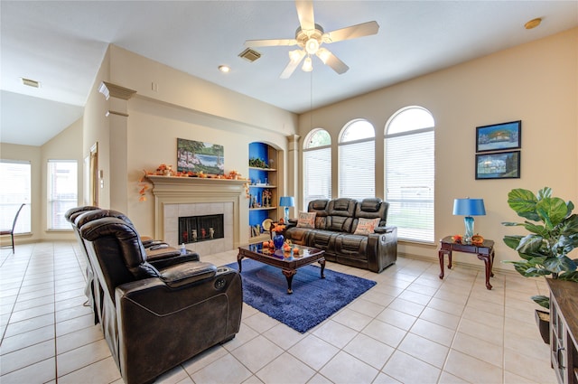 tiled living room featuring a tile fireplace, ceiling fan, and vaulted ceiling