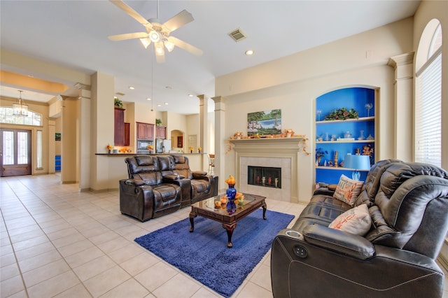 living room featuring a tiled fireplace, a wealth of natural light, light tile patterned floors, and ceiling fan