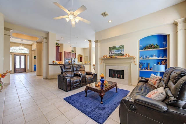 tiled living room with ceiling fan and a tile fireplace