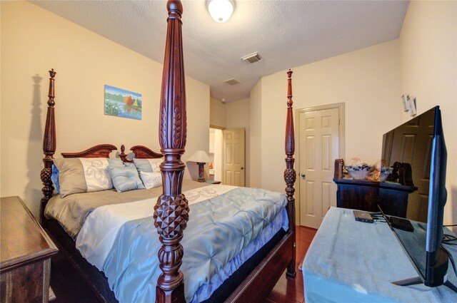 bedroom featuring dark hardwood / wood-style floors, lofted ceiling, and a textured ceiling