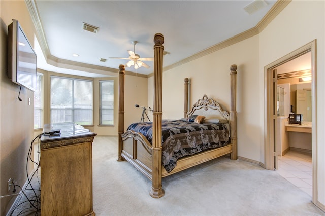 bedroom with ceiling fan, crown molding, light carpet, and ensuite bath