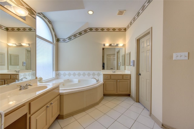 bathroom featuring a bath, a sink, vaulted ceiling, and visible vents