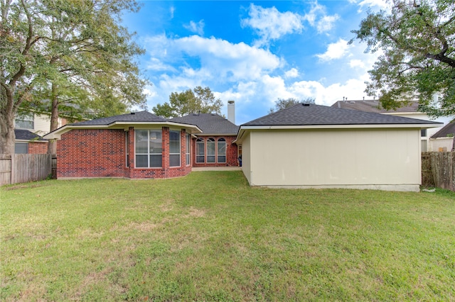 rear view of property with a yard