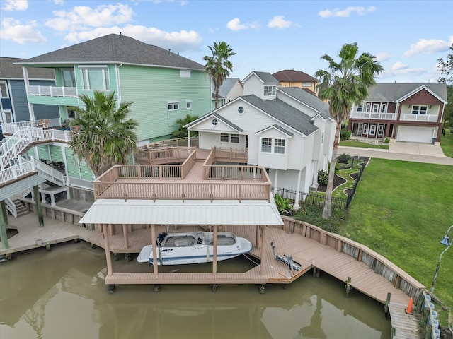 view of dock featuring a deck with water view and a yard