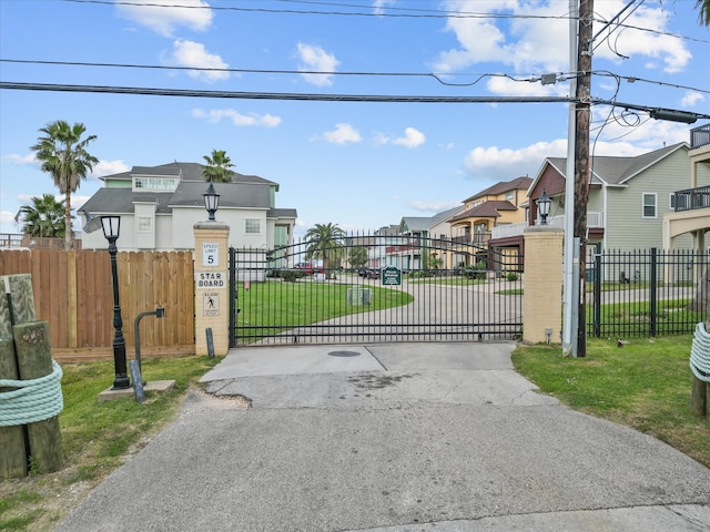 view of gate with a lawn