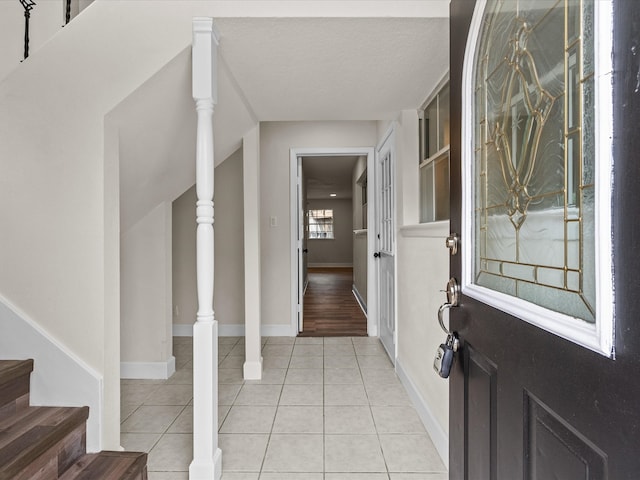 foyer entrance featuring light tile patterned floors and a textured ceiling